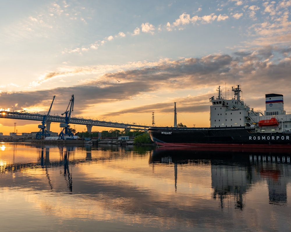 a large boat in the water near a bridge