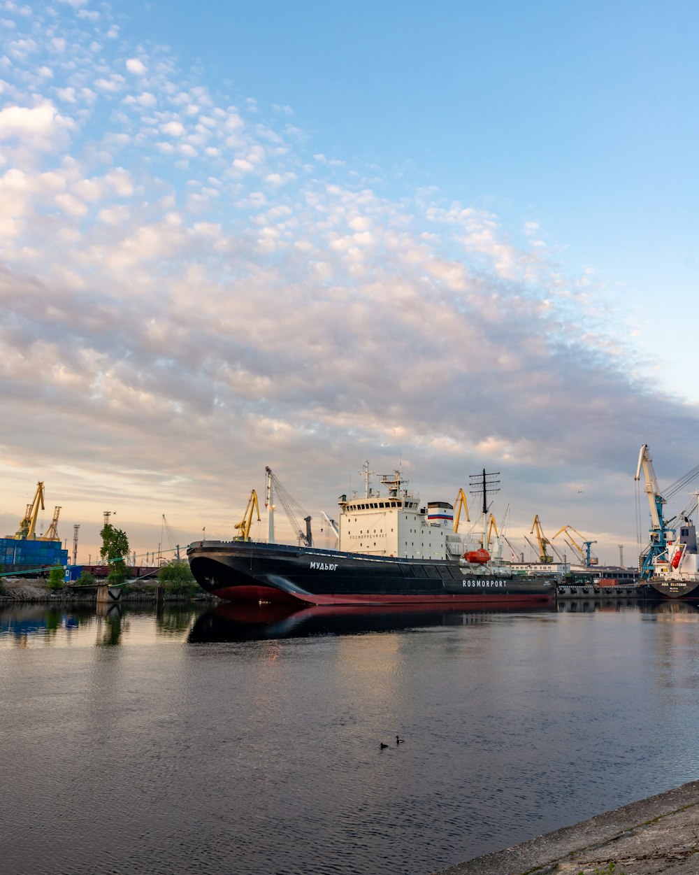 a large boat sitting in the water next to a dock