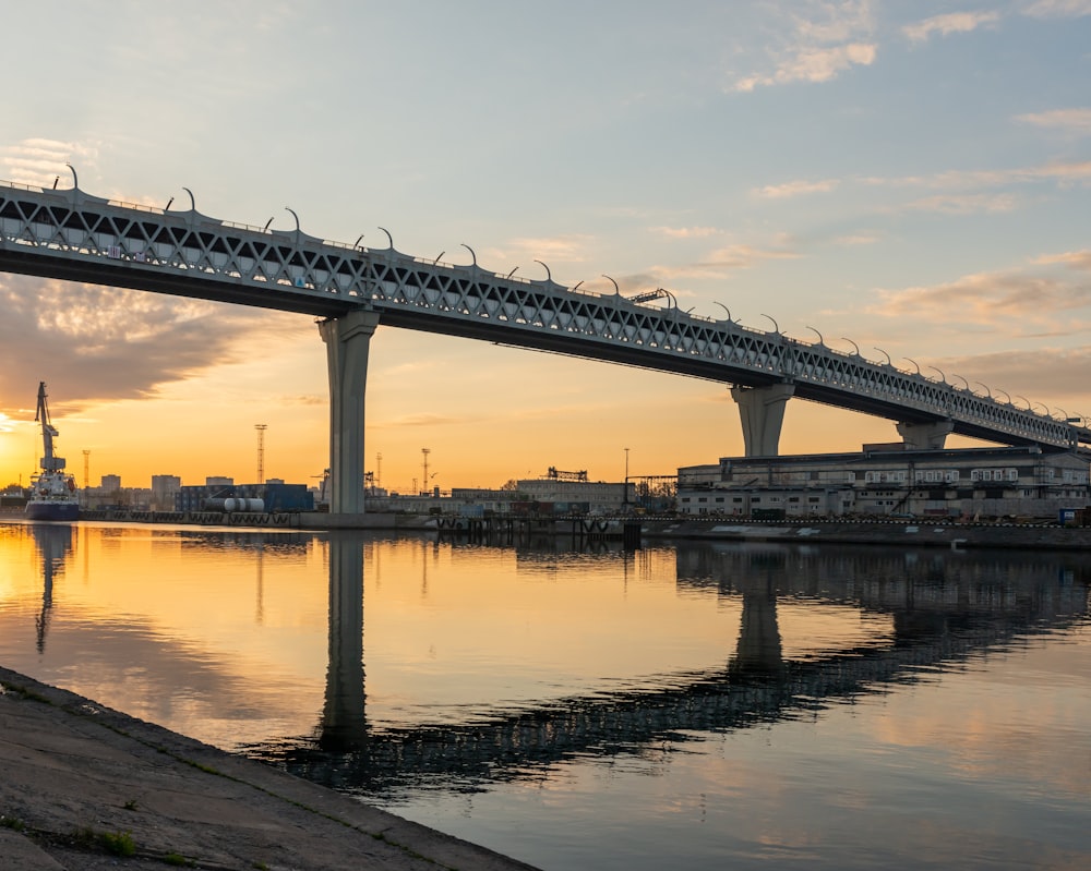 a bridge over a body of water at sunset