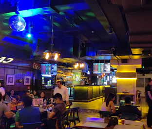 A vibrant scene inside Verdeswing showing friends enjoying golf simulators and drinks amidst modern décor.