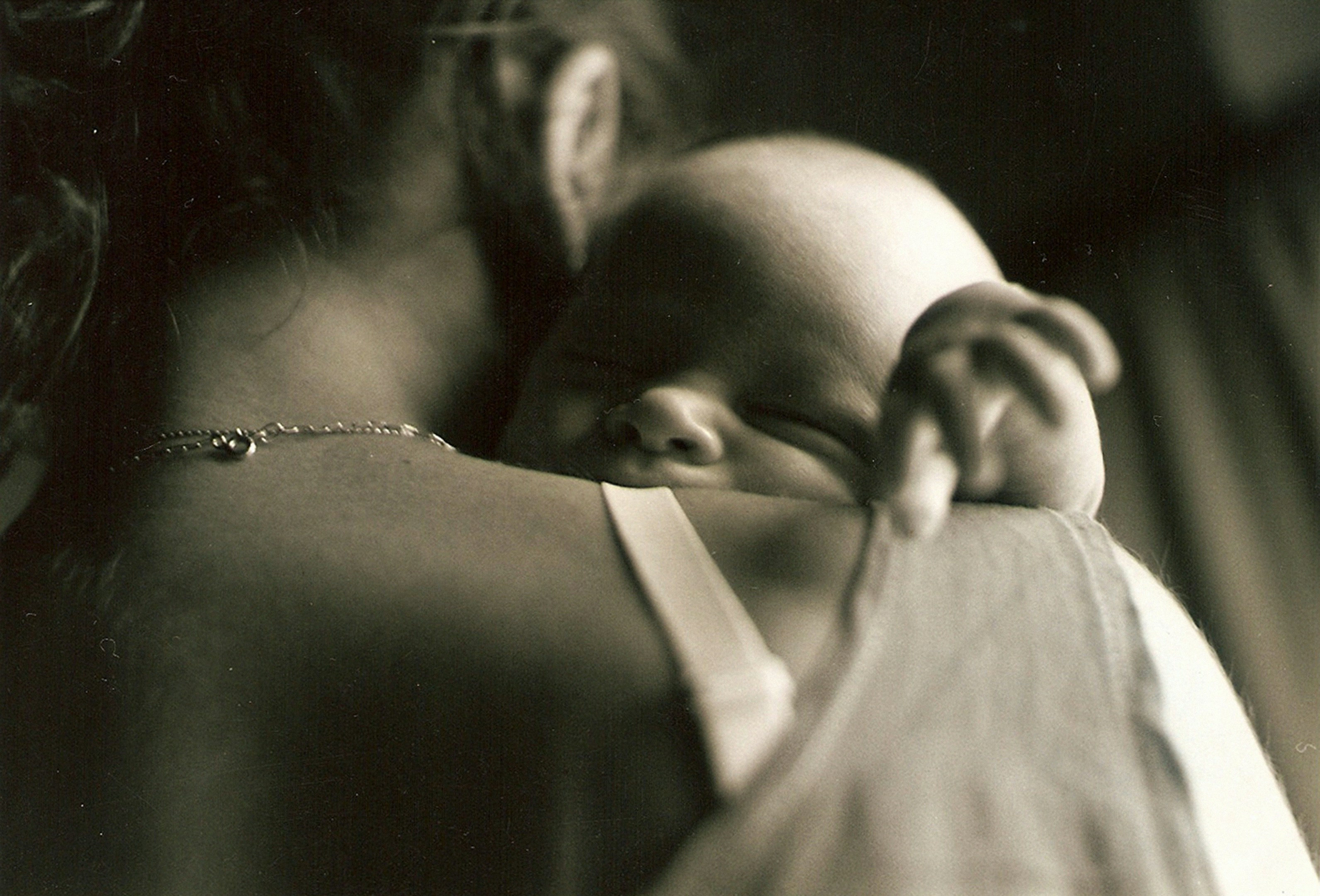 Postpartum mother holding newborn during the fourth trimester at home