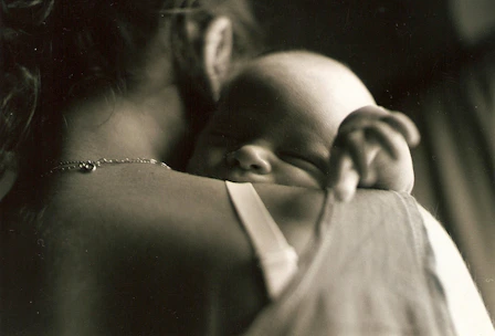 a woman holding a baby in her arms