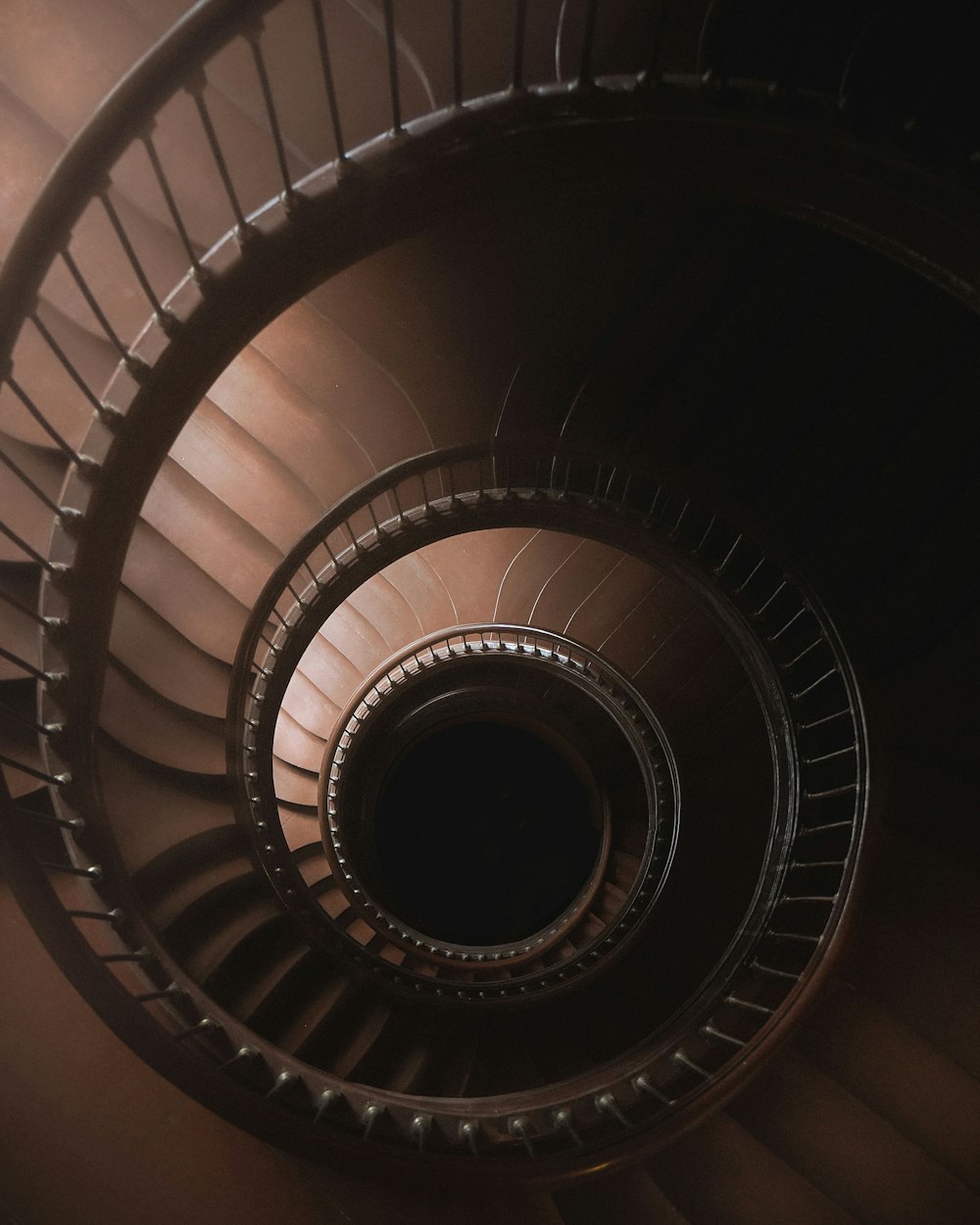 a spiral staircase in a building with a dark background