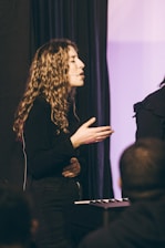 a woman standing in front of a microphone