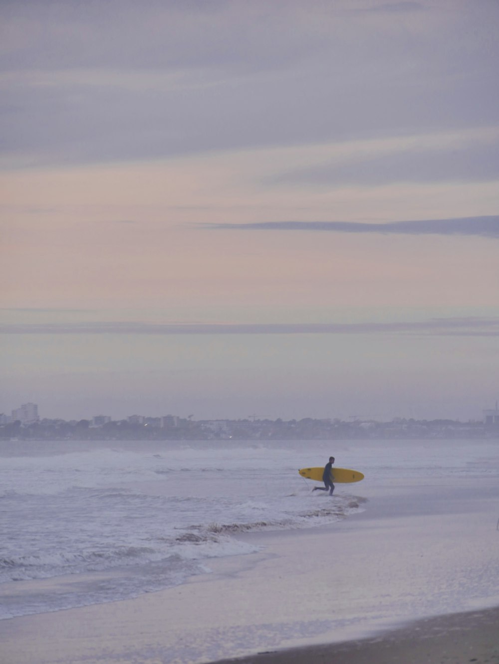 a person holding a surfboard on a beach