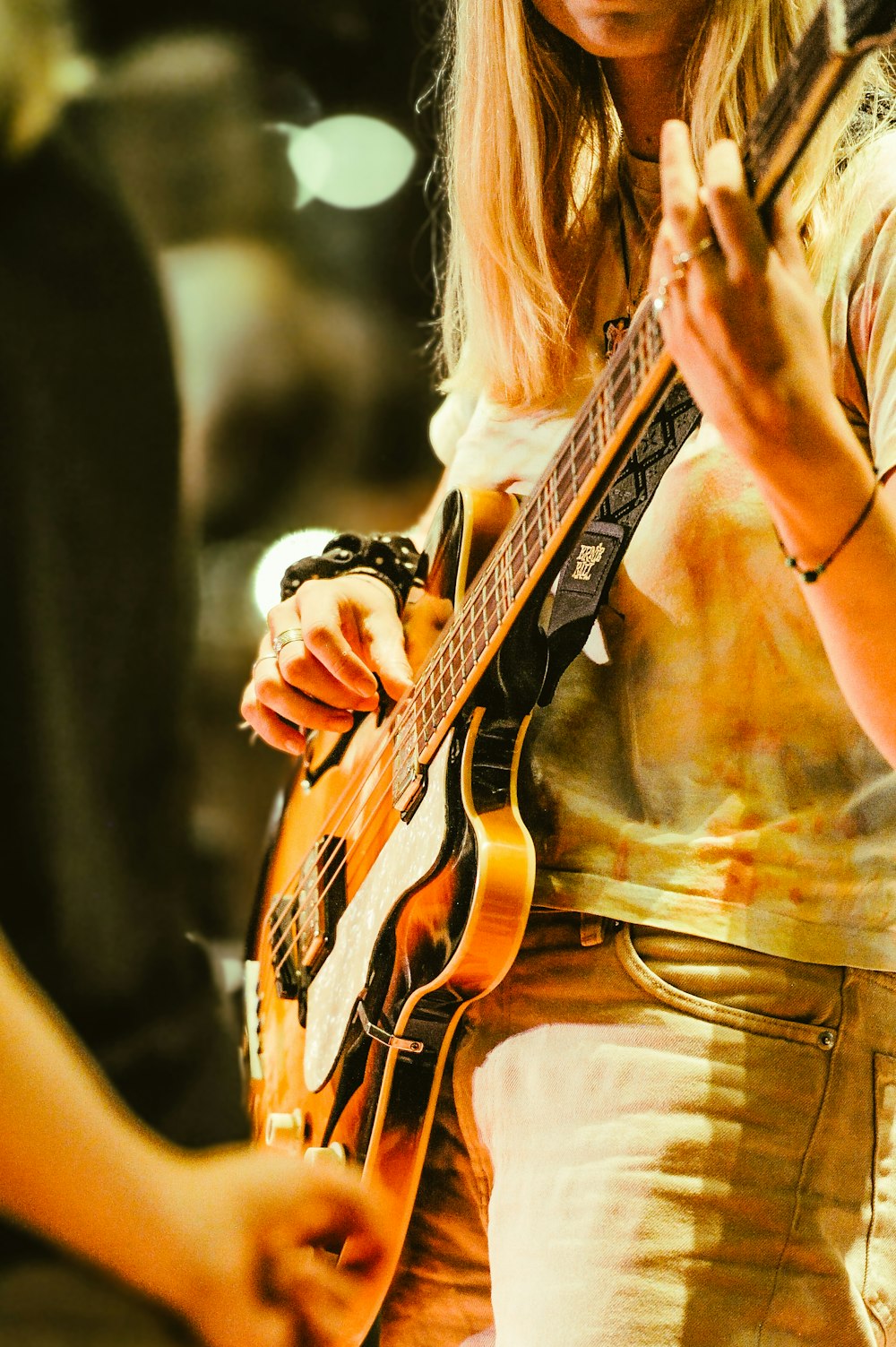 a woman playing a guitar in a band
