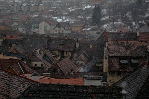 A warm photo of Yekci smiling with a backdrop of Romanian village homes.