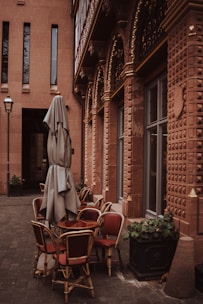 Elegant outdoor seating area shaded by a fixed beige awning with golden accents.