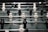 A foosball table with rows of molded players attached to rods, featuring alternating black and white figures. The field is green with marked white lines and goals at each end.