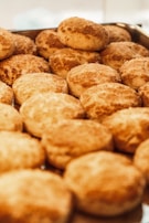 Traditional Brazilian sweet bread rolls arranged neatly on a baking tray.