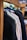 Several jackets are neatly hung on a wooden rack, showcasing a variety of colors and textures. The focus is on the shoulders and upper part of the jackets, with a blurred background that suggests a store setting.