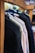 Several jackets are neatly hung on a wooden rack, showcasing a variety of colors and textures. The focus is on the shoulders and upper part of the jackets, with a blurred background that suggests a store setting.