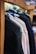 Several jackets are neatly hung on a wooden rack, showcasing a variety of colors and textures. The focus is on the shoulders and upper part of the jackets, with a blurred background that suggests a store setting.