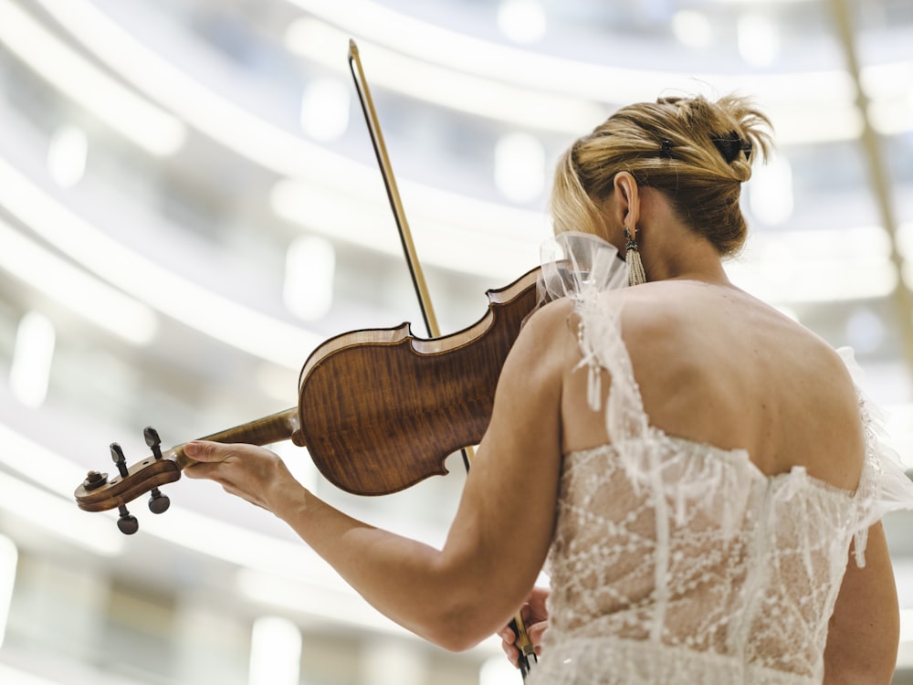 a woman in a white dress playing a violin