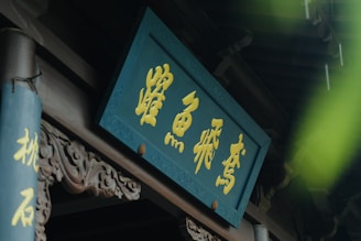 Close-up of intricate gold leaf lettering on a wooden sign