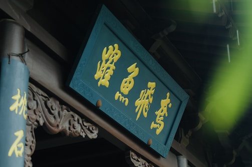 Close-up of intricate gold leaf lettering on a wooden sign