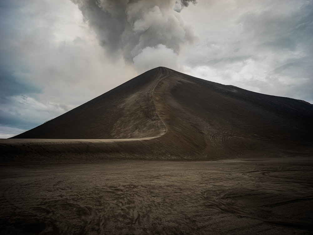 a very tall mountain with a very dark cloud in the sky