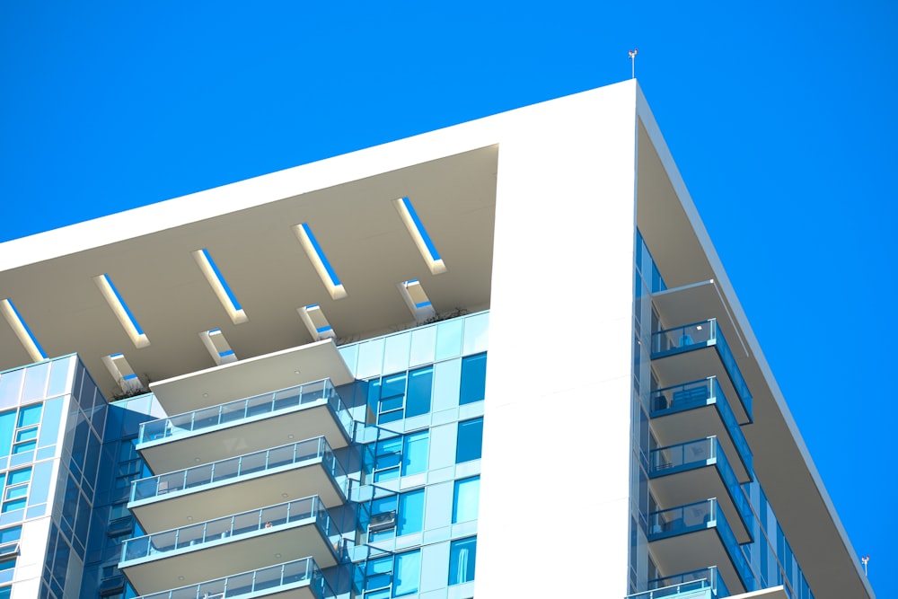 un alto edificio bianco con balconi contro un cielo azzurro