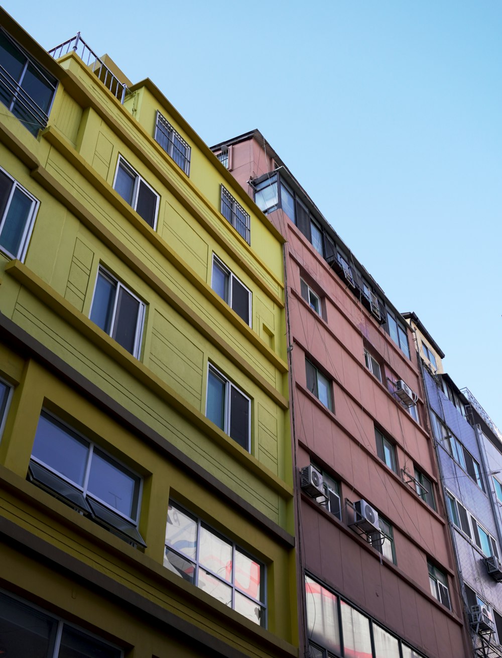 a row of multi - colored buildings with windows and balconies