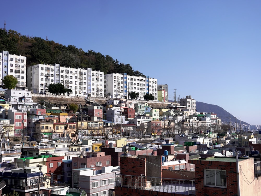 a city with lots of buildings and a hill in the background