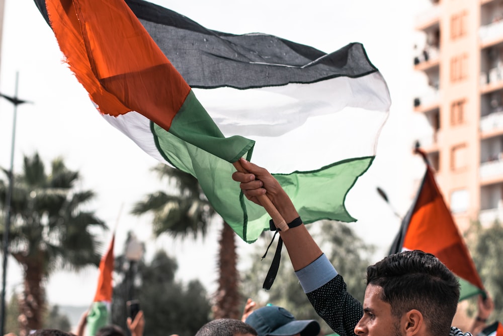 a man holding a flag in a crowd of people