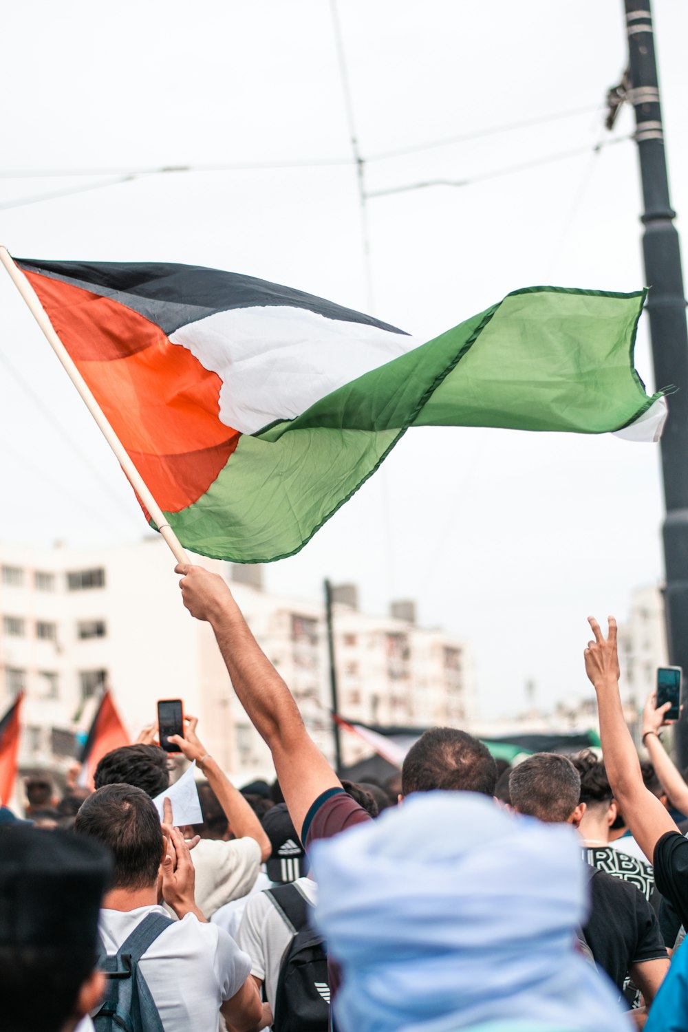 a crowd of people holding up a flag