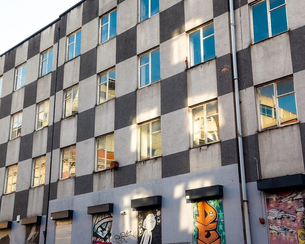 a tall building with lots of windows and graffiti on it