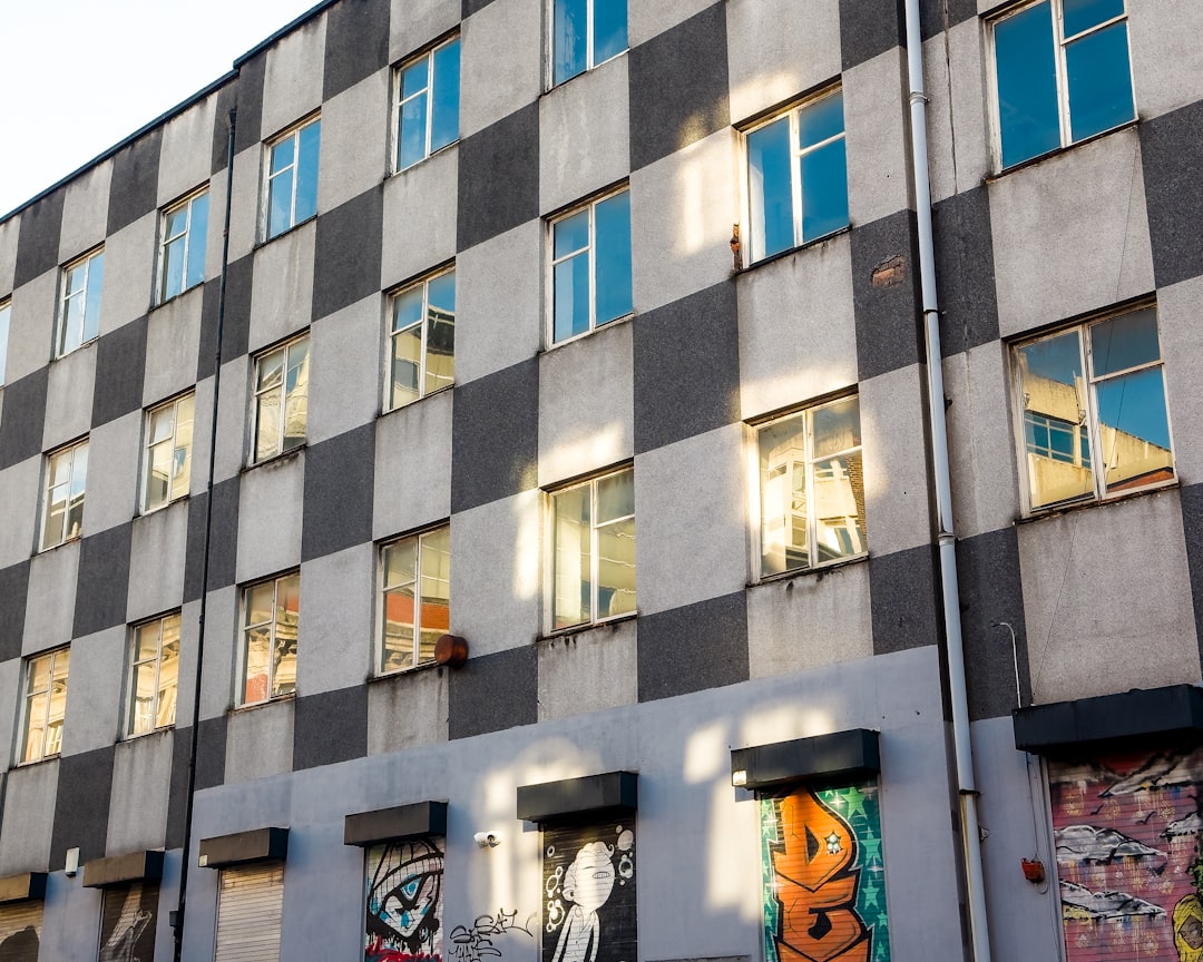a tall building with lots of windows and graffiti on it,