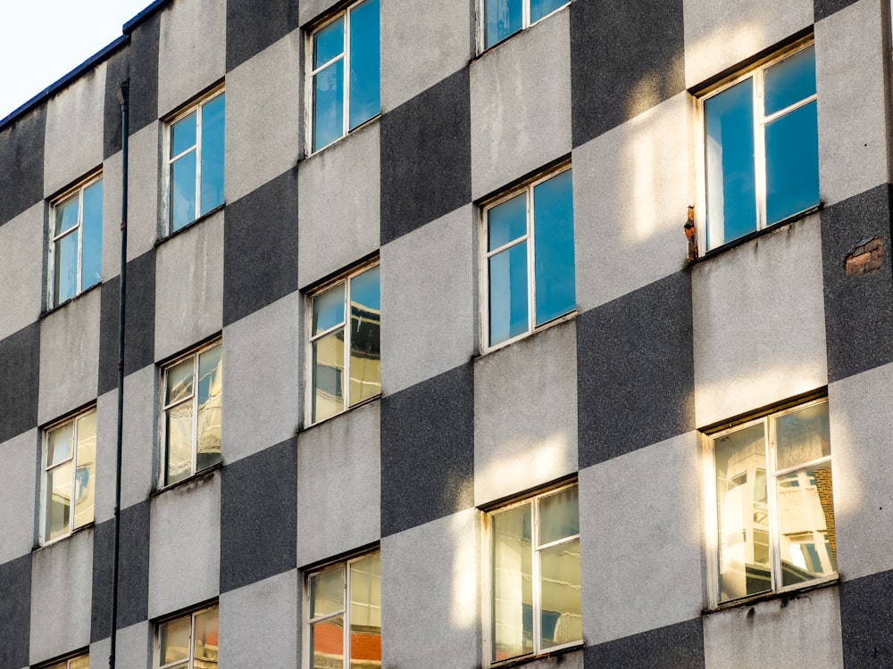 Un edificio alto con muchas ventanas junto a un semáforo