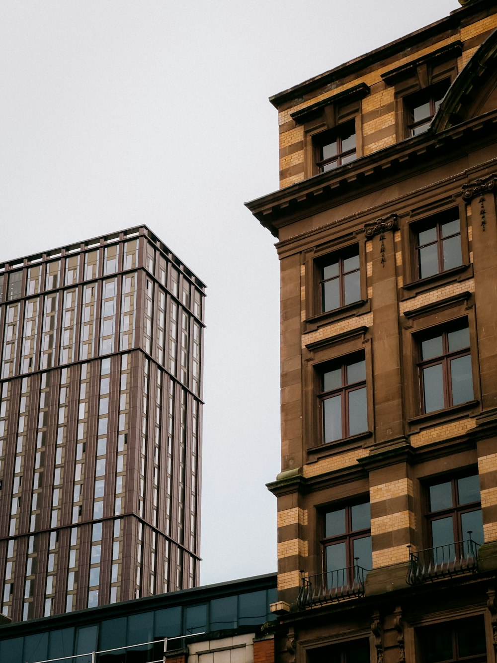 a clock on the side of a building next to a tall building