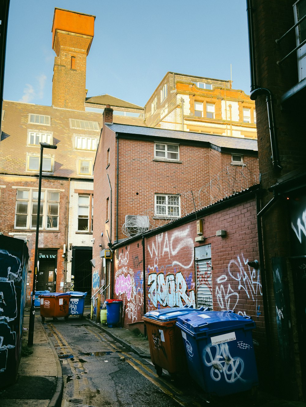 a narrow alley with graffiti on the walls