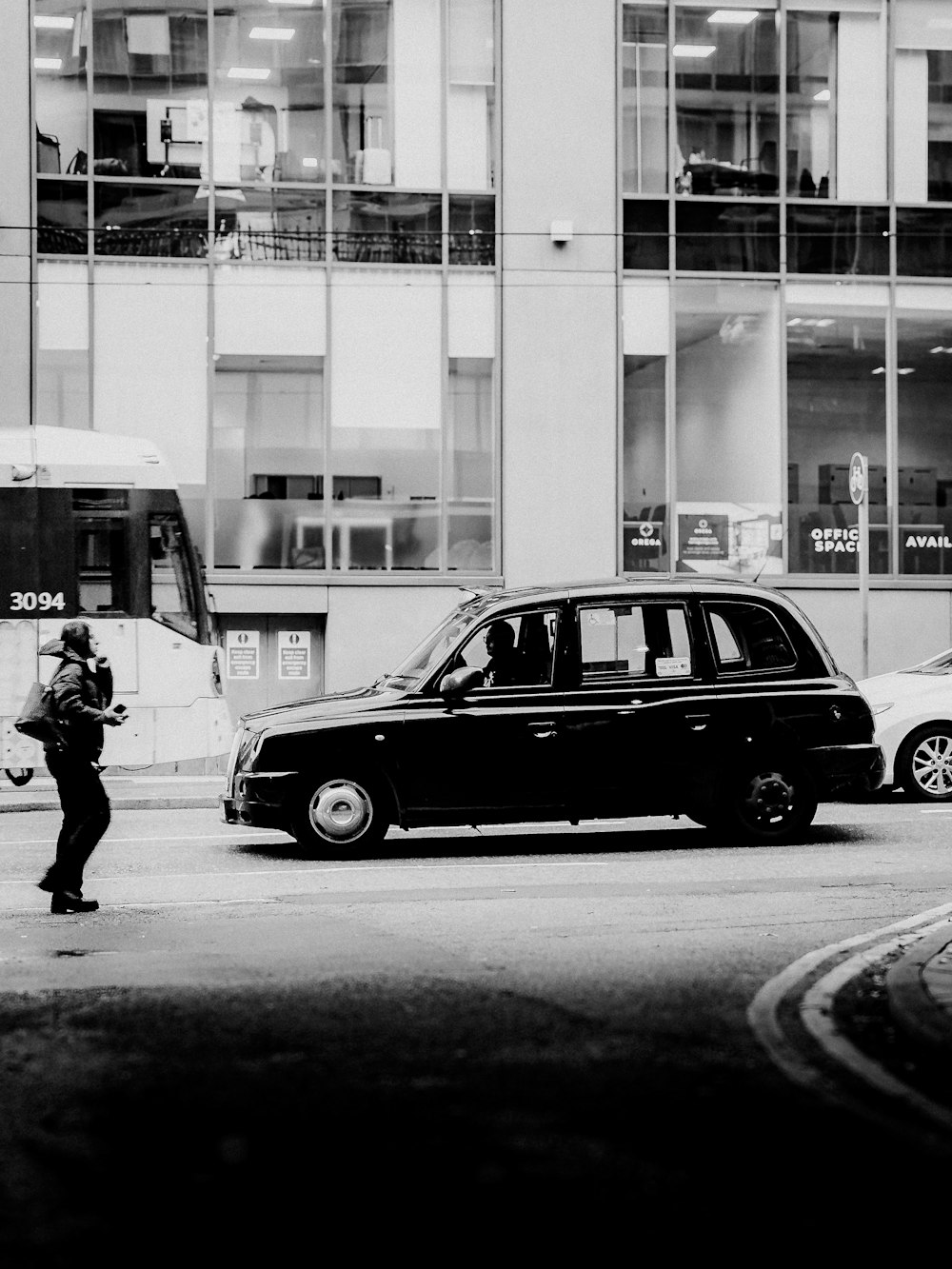 a black and white photo of a taxi and a man
