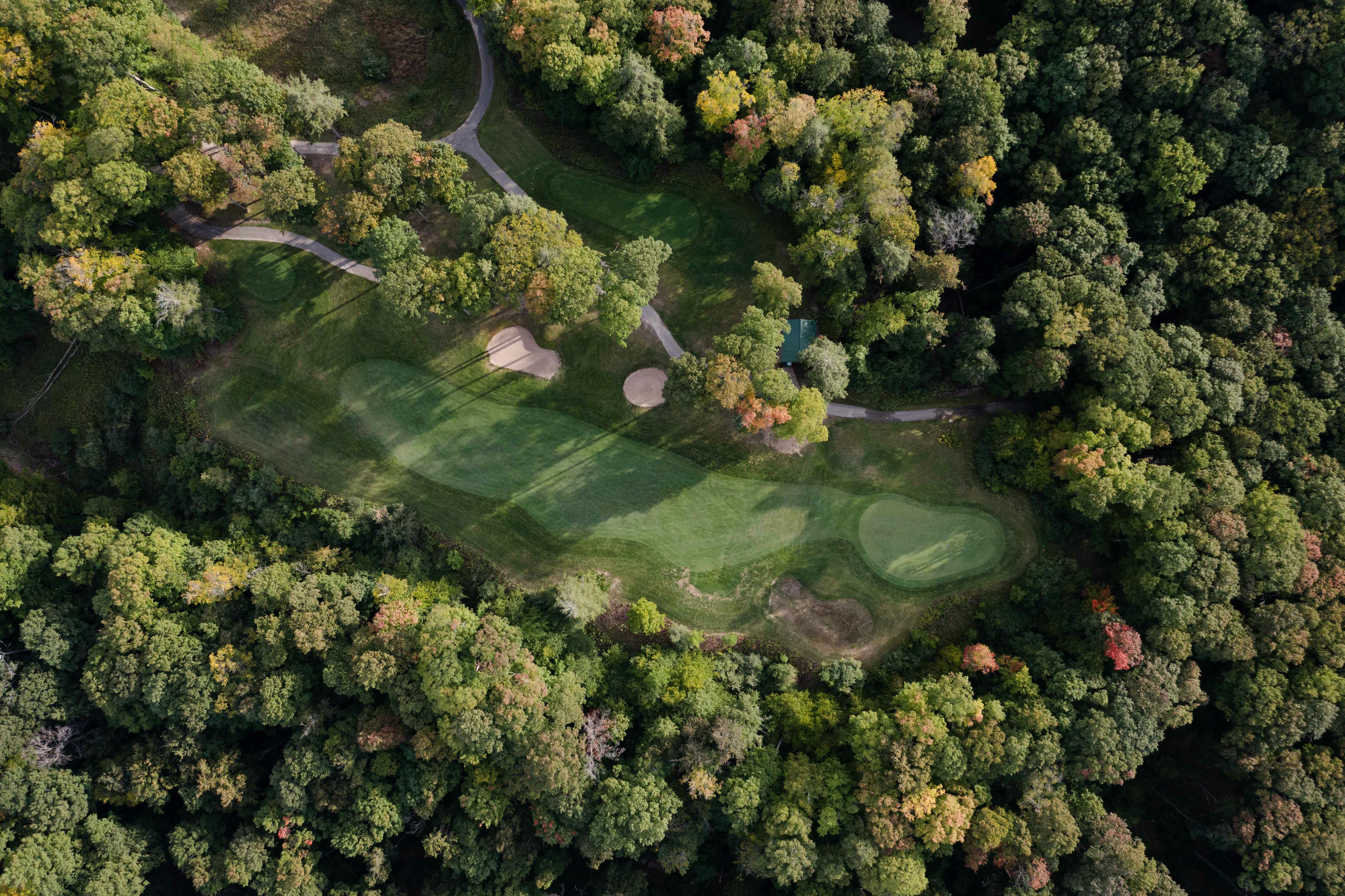 An aerial view of a golf course surrounded by trees photo Free Usa Image on Unsplash