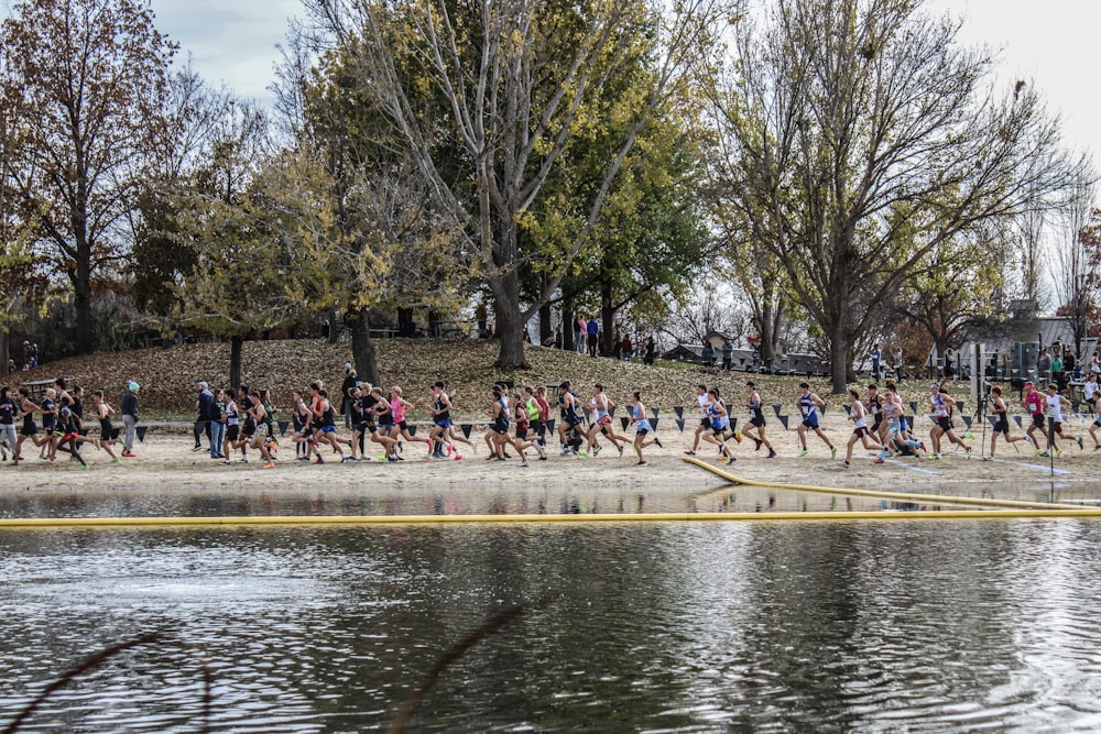 a large group of people are running on the beach