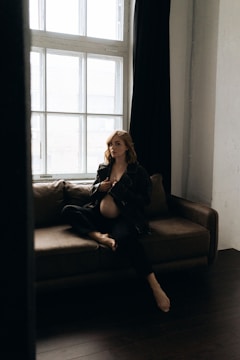 A stylish woman enjoying a peaceful meditation in a cozy, sunlit room.