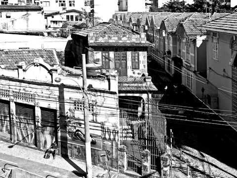 Photograph of a researcher walking through a vibrant Latin American neighborhood, notebook in hand.