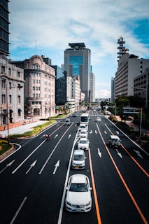 A vibrant city street with various cars driving by.