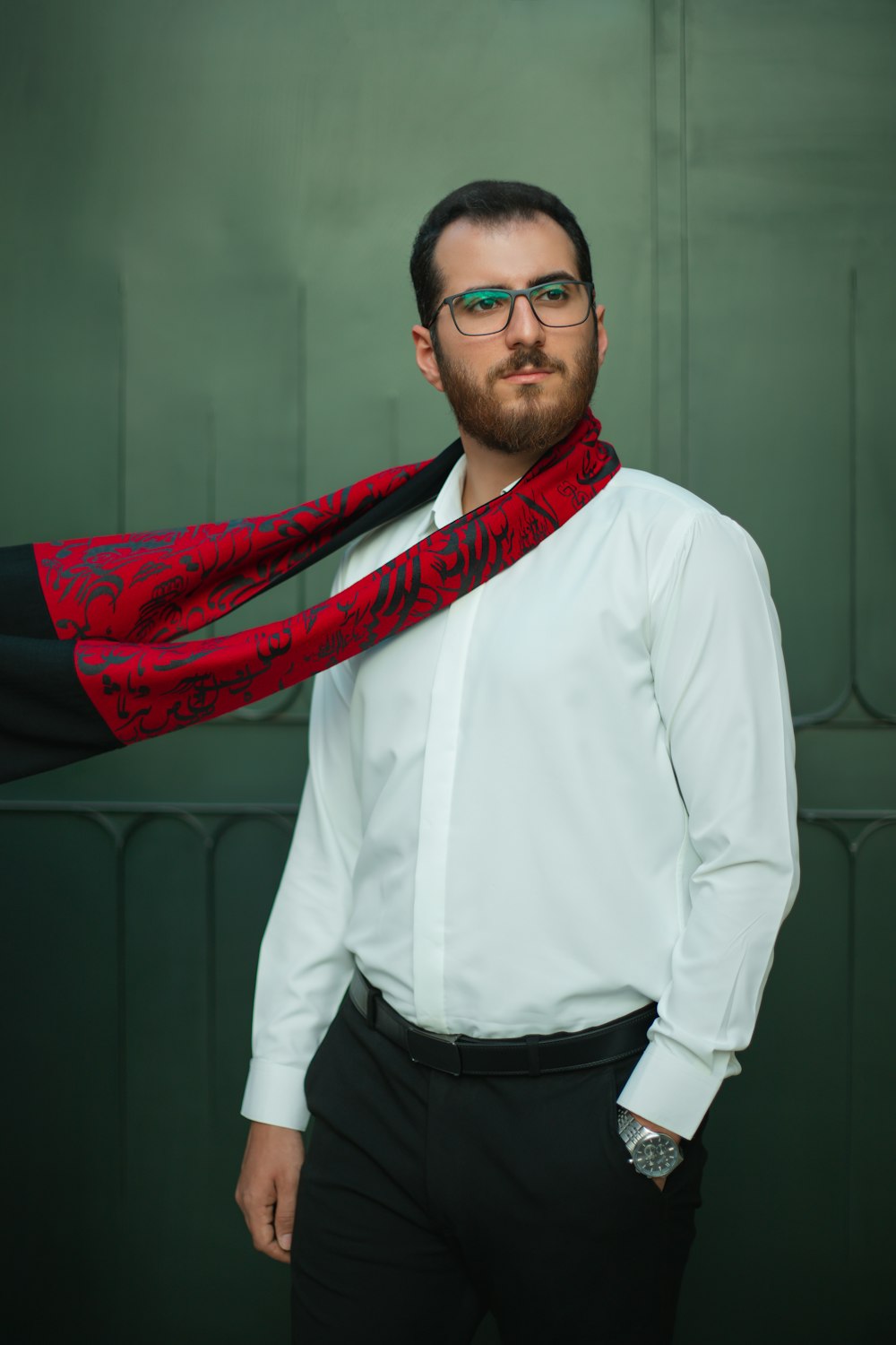 a man wearing a white shirt and a red and black scarf