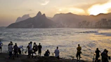 People clinking glasses during a sunset gathering overlooking the water at the breakwall.