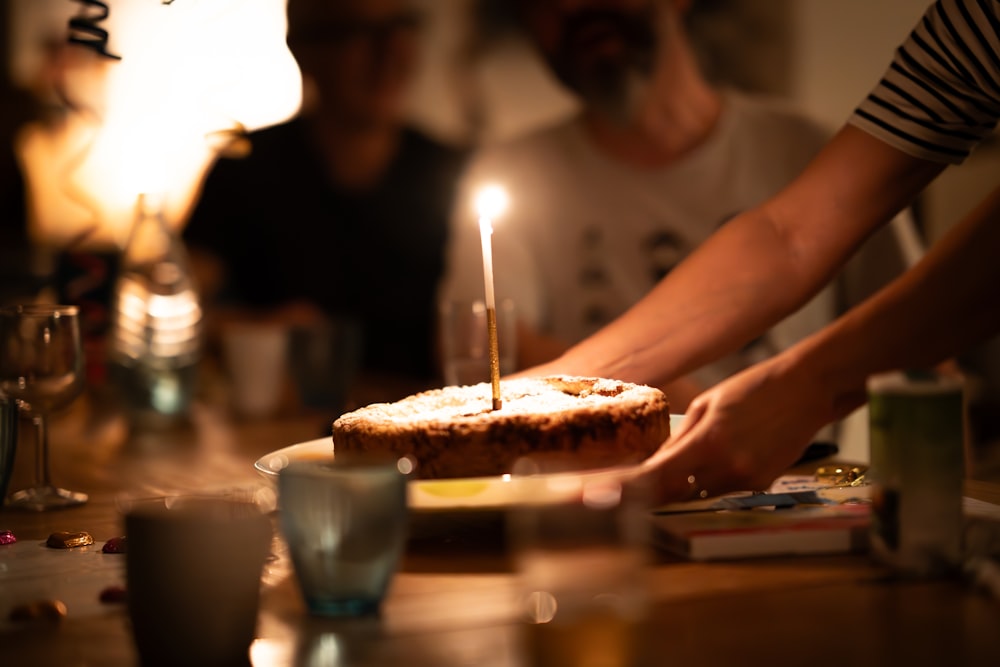 una persona che accende una candela su una torta