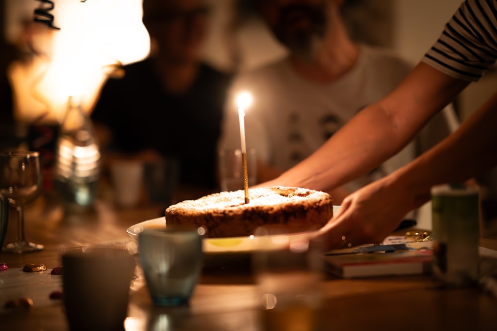 a person lighting a candle on a cake