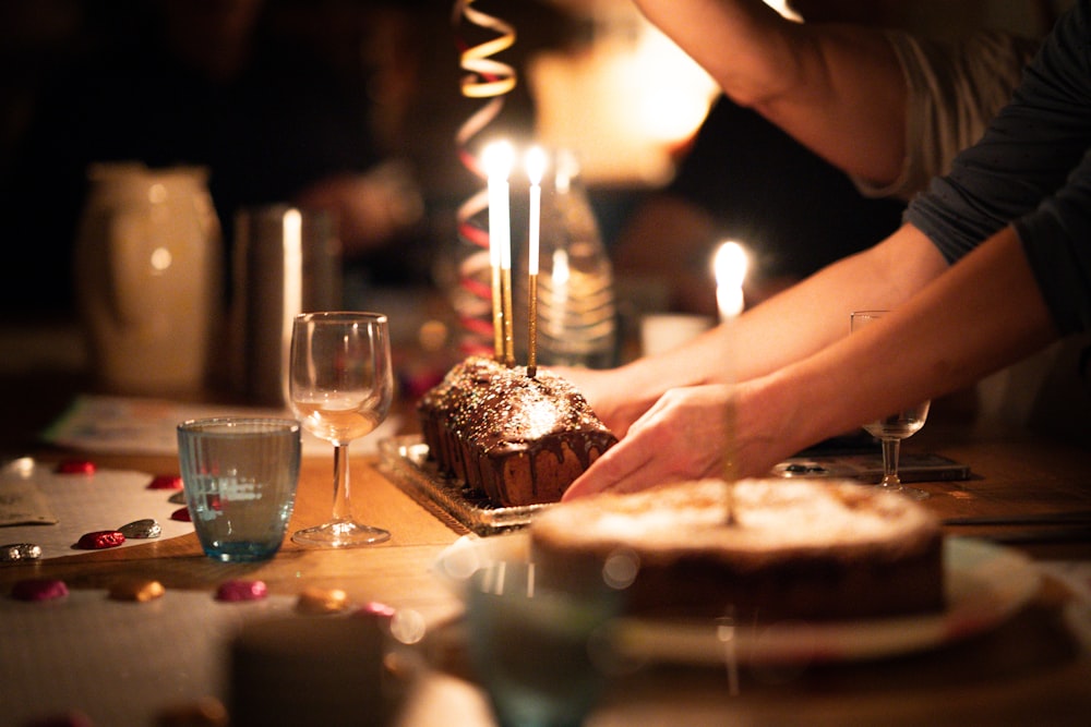 a person lighting candles on a cake on a table