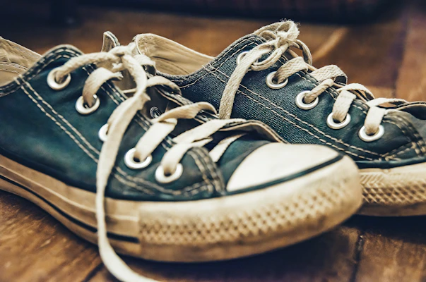 A pair of sturdy canvas sneakers resting on a sunlit porch, showing signs of everyday wear and comfort.