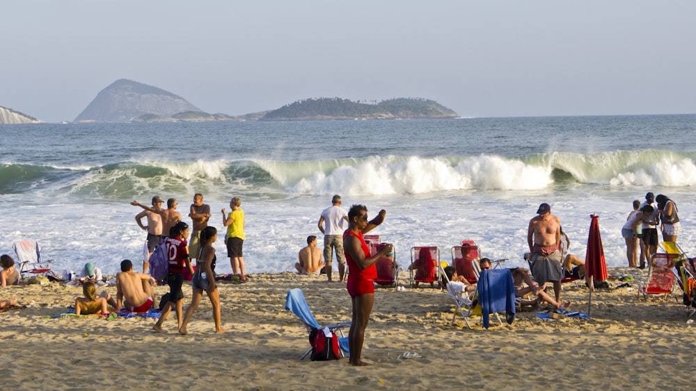 a group of people standing on top of a sandy beach