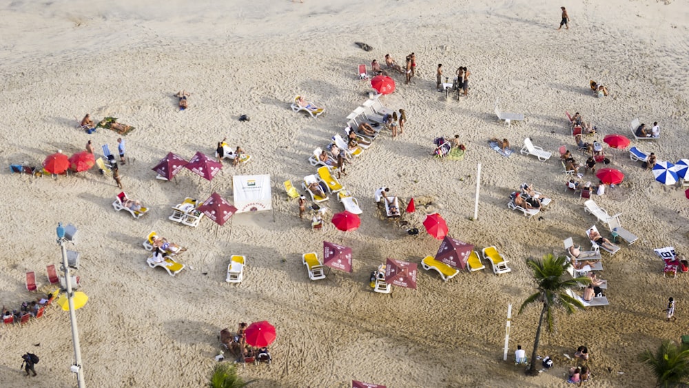 a group of people sitting on top of a sandy beach