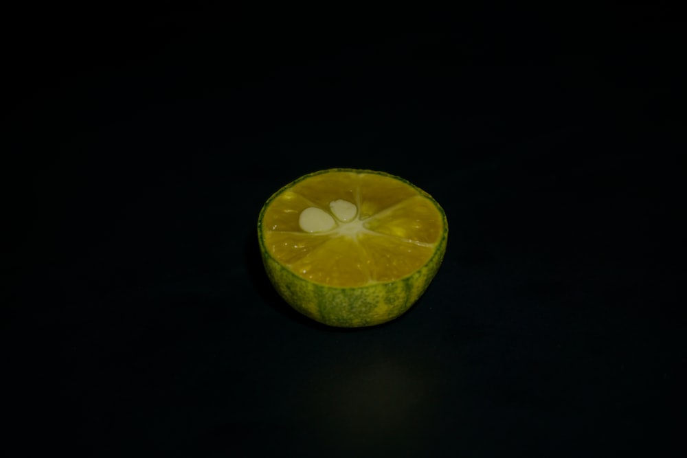 an orange cut in half on a black surface