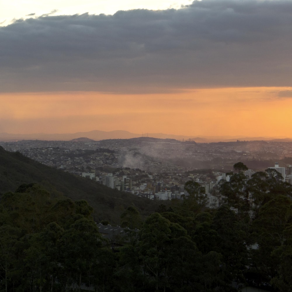 Blick auf eine Stadt von einem Hügel bei Sonnenuntergang
