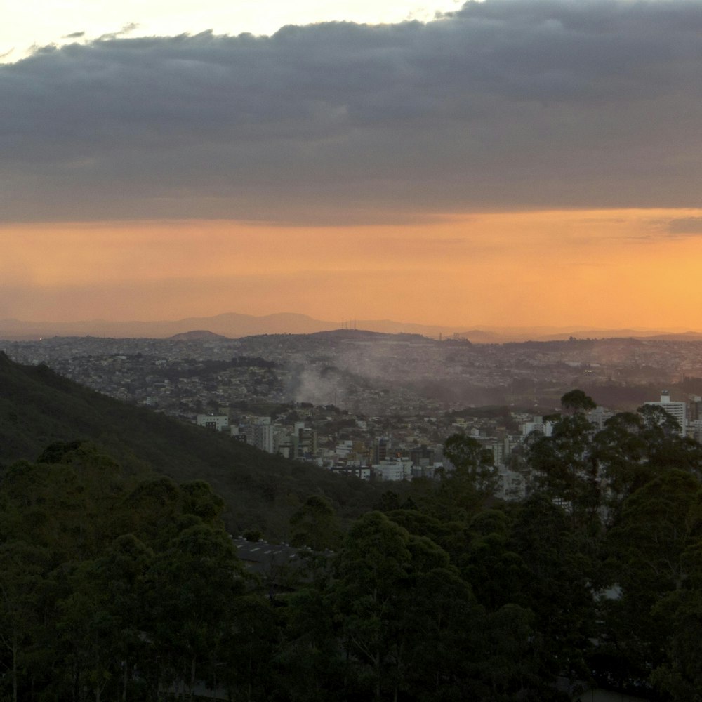 a view of a city from a hill at sunset