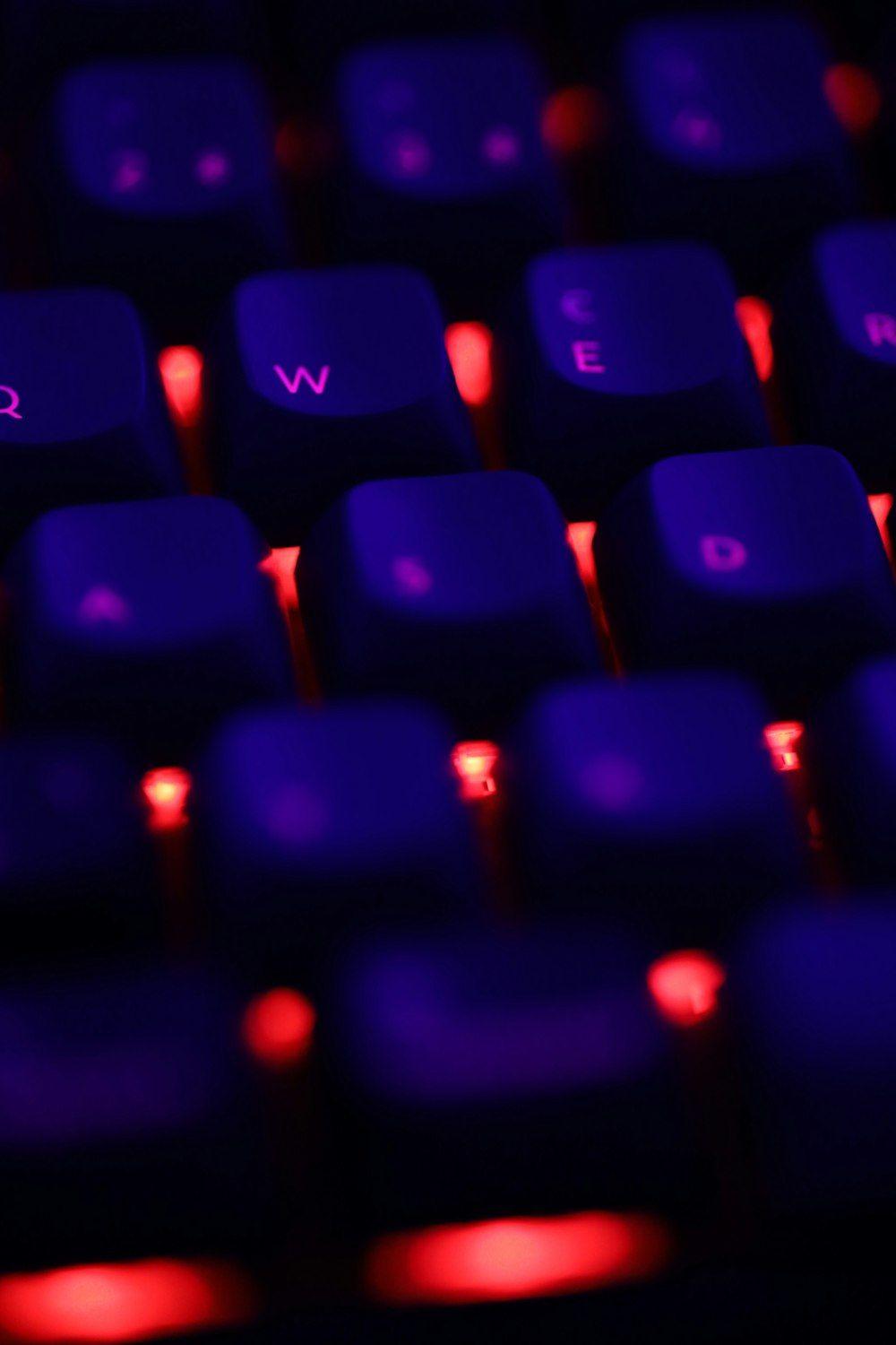 a close up of a purple keyboard with red lights