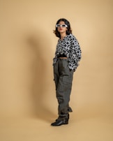 Model posing confidently, wearing oversized black cargo pants paired with a fitted graphic tee and sleek boots.